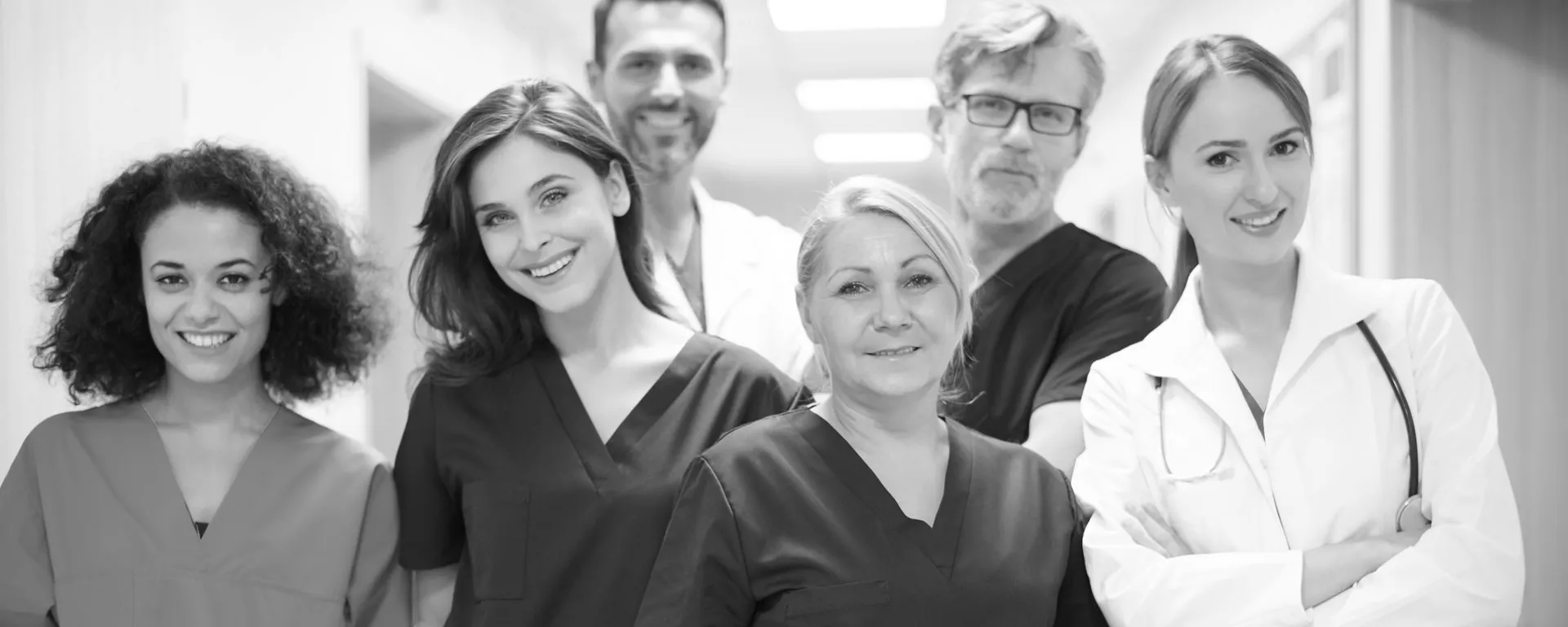 Team von Mitarbeitern in einer Pflegeeinrichtung. Das Team besteht aus Männern und Frauen mit unterschiedlichen Berufen, wie Ärzt:innen und Pfleger:innen